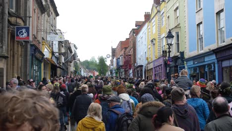 Packed-streets-with-crowds-of-people-celebrating-Beltane-May-Day-in-Glastonbury-town,-Somerset-UK