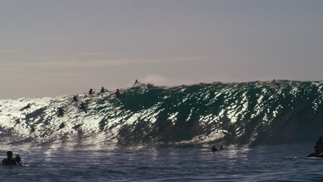 Panoramic-view-of-surfers-in-lineup-attempting-to-catch-monster-wave