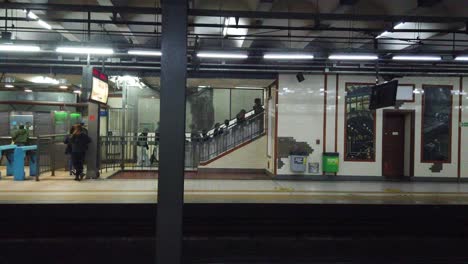 Menschen-Gehen-In-Einer-Reihe-Auf-Den-Außenaufzug-Zu,-Einer-Alten-U-Bahn-Station-In-Der-Stadt,-Die-Den-Bau-Einer-U-Bahnstation-Plant.