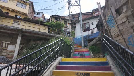 Colorful-stairs-guide-the-way-through-Comuna-13,-a-vibrant-neighborhood-in-Medellin,-showcasing-urban-art-and-community-spirit