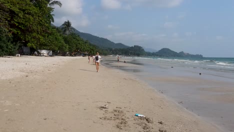 Tiefflug-Entlang-Des-Weißen-Sandstrandes-Von-Koh-Chang-Mit-Touristen,-Die-Den-Tag-Genießen