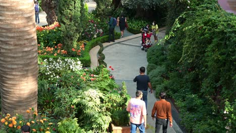 Gente-Paseando-Por-El-Camino-Del-Campo-De-Flores,-Explorando-La-Popular-Atracción-Turística-De-Singapur,-Invernadero-De-Cristal-Con-Cúpula-De-Flores-En-Los-Jardines-Junto-A-La-Bahía-Con-Flores-De-Temporada-En-Exhibición