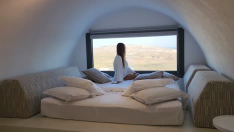 Una-Mujer-Mira-Por-La-Ventana-En-Un-Exótico-Dormitorio-Con-Techo-De-Arco-En-Italia