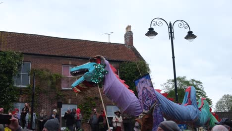 Close-up-of-colorful-dragon-swaying-and-dancing-at-cultural-Beltane-May-Day,-beginning-of-summer,-festival-celebrations-in-Glastonbury-town,-Somerset-UK