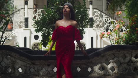 Embracing-the-ambiance-of-a-Caribbean-castle,-a-young-woman's-red-gown-adds-a-dash-of-color-to-the-ancient-surroundings