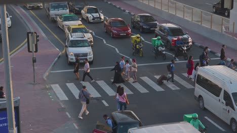 überzeugendes-4K-Filmmaterial-Mit-60-Bildern-Pro-Sekunde,-Das-Menschen-Zeigt,-Die-Abends-überflutete-Straßen-In-Der-Nähe-Der-U-Bahn-Station-ADCB-In-Dubai-überqueren