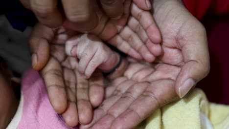 Bienvenida-De-La-Mano-Del-Recién-Nacido-Con-La-Mano-De-Otros-Miembros-De-La-Familia-En-Casa