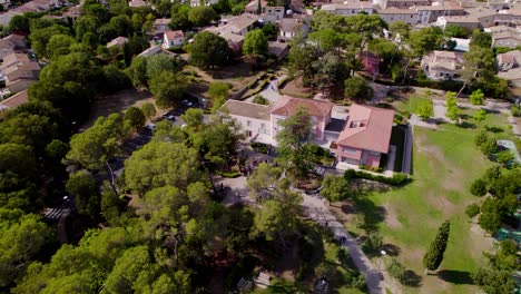 Aerial-view-above-big-property-mansion-in-Montpellier,-with-people-gathered-for-the-wedding-party