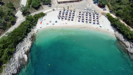 Aerial-Orbit-over-Ammoussa-Beach-Bay,-Sun-Umbrellas,-Lefkada,-Greece
