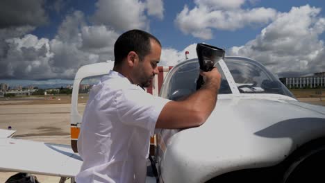 Pilot-letting-the-oil-drain-from-the-funnel-after-having-poured-it-under-a-beautiful-sky