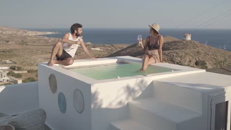 young-millenial-couple-enjoy-sipping-wine-on-rooftop-luxury-hotel-spa-suite