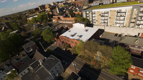 FPV-Drohnenflug-über-Häuser-Und-Wohnblöcke-Mit-Grünen-Dächern-In-Einer-Amerikanischen-Stadt-Bei-Sonnenuntergang