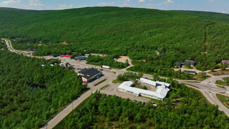 Aerial-view-following-a-truck-driving-through-the-Utsjoki-village,-in-Lapland