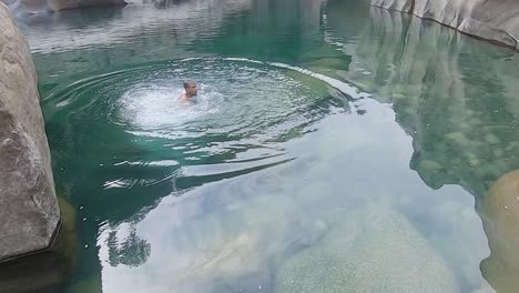 Hombre-Nadando-En-El-Río-De-Montaña-Agua-Azul-Clara-Durante-El-Día