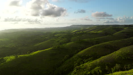 Golden-hour-aerial-riser-view-over-lush-rolling-hills-of-Nusa-Penida-landscape