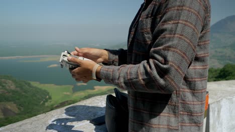 Indischer-Professioneller-Drohnenpilot-Faltet-Die-Drohnenarme-Nach-Einem-Überwachungsflug-In-Der-Wildtierlandschaft,-Indien