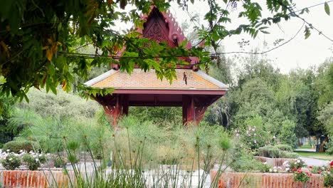 Inside-Plaza-Tailandia-green-urban-park-with-Thai-theme-temple-in-Santiago-de-Chile-South-American-Capital,-calm-water-pond-around-Thailand-style-architecture