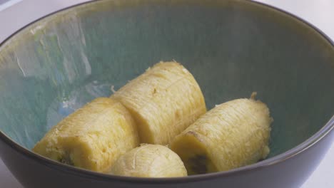 Putting-steaming-hot-peeled-plantain-bananas-on-a-bowl