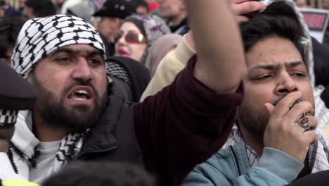 A-bearded-man-wearing-a-Palestinian-Keffiyeh-scarf-on-his-head-holds-up-a-mobile-phone-and-shouts-and-angrily-gestures-towards-counter-protestors-during-the-annual-Al-Quds-day-demonstration