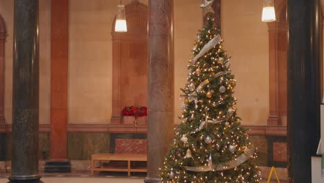 Tilt-down-closeup-shot-of-beautiful-decorated-Christmas-tree-in-National-museum-of-Ireland,-Interior-view