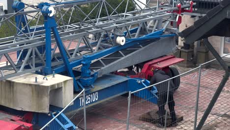 Industrial-worker-during-building-phase-of-construction-site-with-high-crane