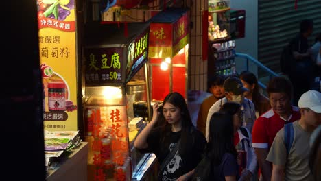 Gente-Paseando-Por-La-Antigua-Calle-De-Jiufen-Llena-De-Puestos-De-Comida-Y-Tiendas-De-Recuerdos,-Explorando-El-Encantador-Pueblo-De-Montaña-Por-La-Noche,-Atracción-Turística-Popular-De-Taiwán