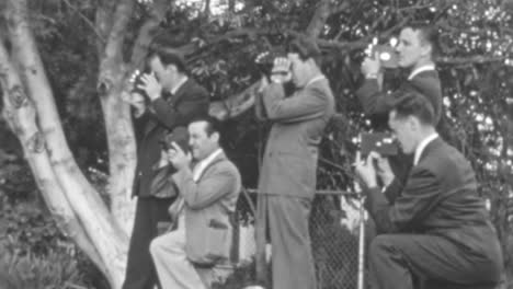 Un-Grupo-De-Fotógrafos-Toma-Fotografías-En-Una-Zona-Al-Aire-Libre-Durante-El-Día-En-La-Década-De-1930.