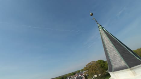 Aerial-approaching-shot-of-church-in-Elizabethtown,-Lancaster-and-main-street-with-traffic-during-sunny-day-in-Pennsylvania