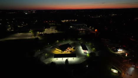 Luftaufnahme-Einer-Beleuchteten-Tankstelle-In-Amerika-Von-Oben-Nach-Sonnenuntergang