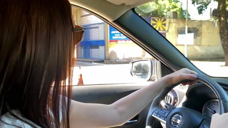 Mujer-De-Unos-30-Años-Con-Gafas-De-Sol-Conduciendo-Un-Coche,-Primer-Plano