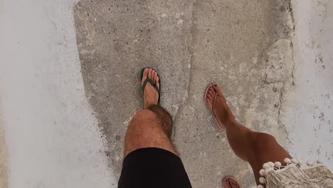 Man-and-women-strolling-feet-on-summer-vibes-in-a-Greek-street