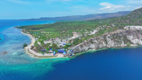 -JML-Beach-House-beach-Resort-with-turquoise-water-and-water-park-at-coastline-of-Sarangani-Bay-with-Blue-Lagoon,-Philippines,-Aerial-approaching-shot