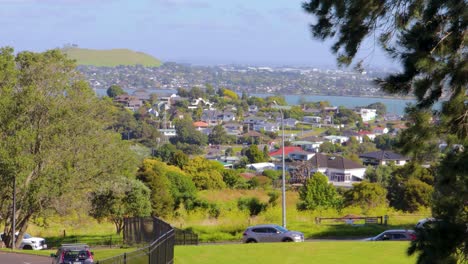 Panoramic-view,-Road-Traffic-in-New-Zealand-countryside,-Auckland,-busy-cars-driving-with-city-background