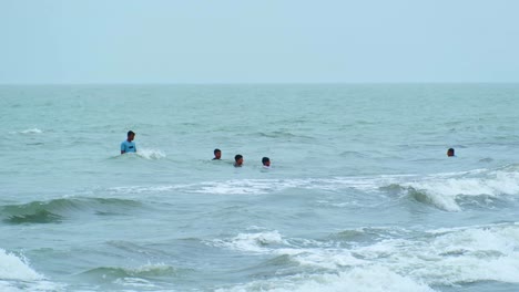 Tourist-people-enjoying-bath-in-sea-water-at-Kuakata,-Bangladesh-among-a-cyclone-or-storm-forecast