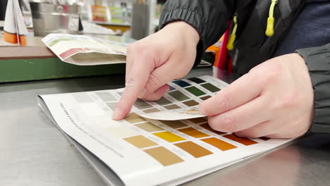 Man-taking-a-color-card-to-match-paint-color-samples-inside-Home-Depot-store