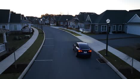 Modernes-Viertel-Mit-Elektrischem-Tesla-Model-Y,-Das-Bei-Sonnenuntergang-Fährt