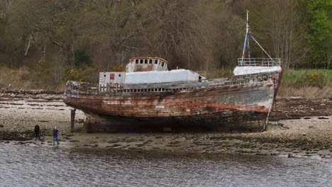 Aerial-establishing-shot-of-a-tourists-standing-at-the-Corpach-Shipwreck