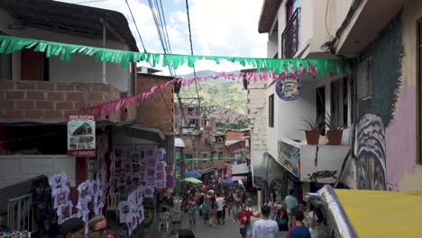 Bulliciosa-Escena-Callejera-En-La-Comuna-13-De-Medellín,-Adornada-Con-Coloridas-Pancartas-Y-Arte-Callejero