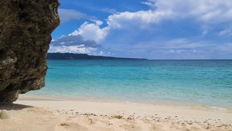 Tropical-Paradise,-White-Sand-Beach,-Turquoise-Sea-and-Rock-Static-Shot-60fps