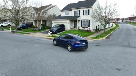 Tesla-driving-in-modern-American-neighborhood-during-spring