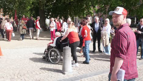 Elderly-woman-in-wheelchair-holding-a-rose-at-rally