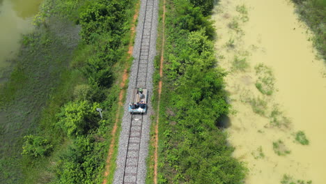 Bambusbahn-Battambang-Drohne-Verfolgt-Eisenbahnwaggon-Von-Oben-In-Der-Heißen-Kambodschanischen-Sonne