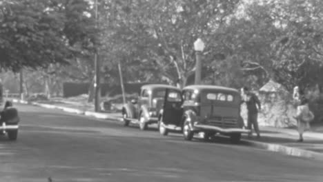 Vintage-Straßenszene-Mit-Klassischen-Autos-Und-Fußgängern-An-Einem-Sonnigen-Tag-In-Schwarzweiß