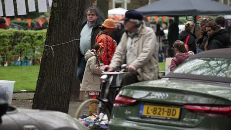 Girl-and-her-mother-look-at-things-on-the-street-during-King's-Day-flea-market-handheld