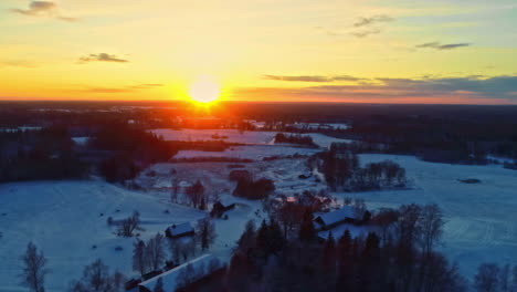 Verschneites-Dorf-Auf-Dem-Land-Bei-Sonnenuntergang-Im-Winter---Gleitende-Luftaufnahme