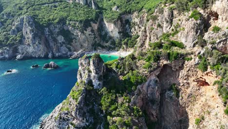 Giali-beach-in-corfu,-greece-with-turquoise-waters-and-rugged-cliffs,-aerial-view