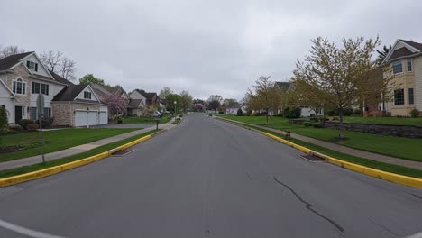 Pov-flight-over-street-in-american-residential-area-with-homes-and-houses-during-cloudy-day