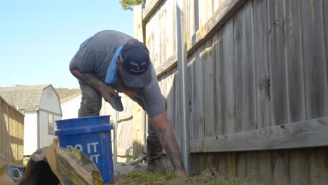 Worker-is-engrossed-in-task-of-repairing-a-wooden-fence