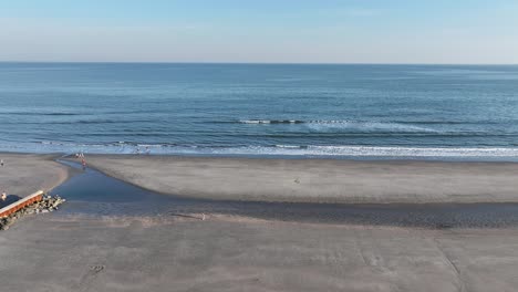 Folly-Beach,-Charleston,-South-Carolina,-Wunderschöner-Sandstrand-Am-Meer,-Ebenerdiger-Blauer-Himmel