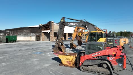 Excavadora-Industrial-De-Volvo-Y-Pequeña-Excavadora-De-Kubota-En-La-Zona-Industrial-Del-Suburbio-Americano